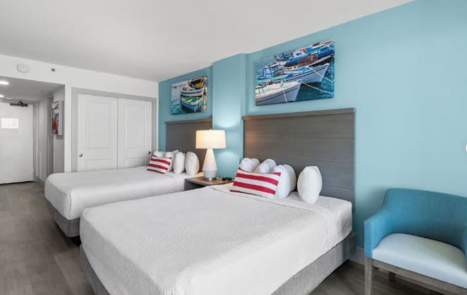 Stretch out in crisp linens under calming coastal artwork.