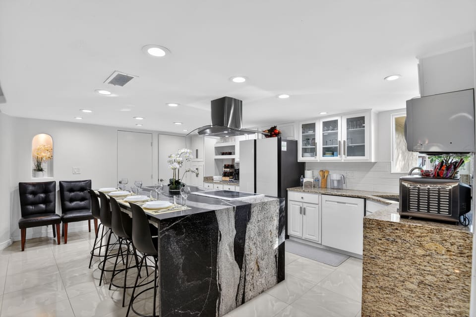 An elegant kitchen island with curated bar seating extends the dining experience