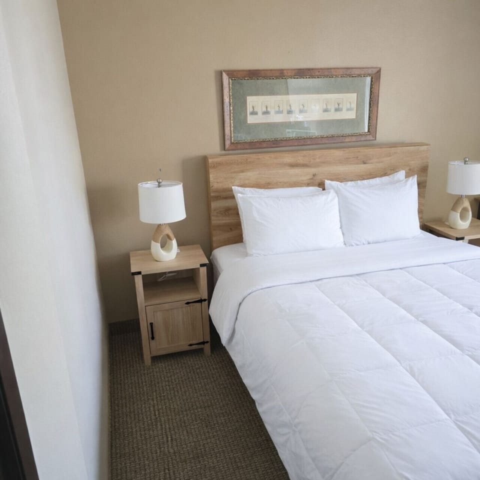 Cozy queen bedroom with soft linens, natural light, and a peaceful lake-country feel