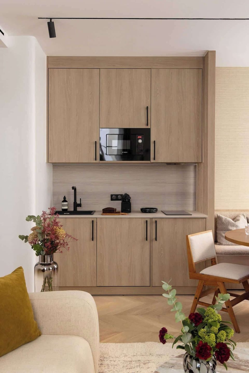 Une cuisine ouverte, parfaitement équipée de tous les éléments essentiels : réfrigérateur, plaques de cuisson, machine à café, grille-pain, bouilloire, micro-ondes...