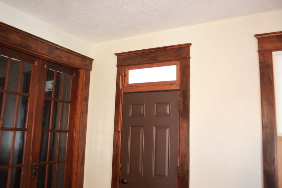 Living room into mudroom showcase old window with copper opener and glass doors