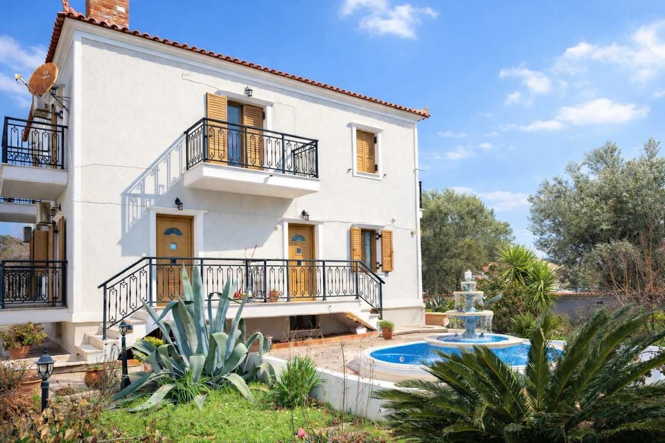 Exterior of the house surrounded by greenery in the peaceful village of Vatoussa.