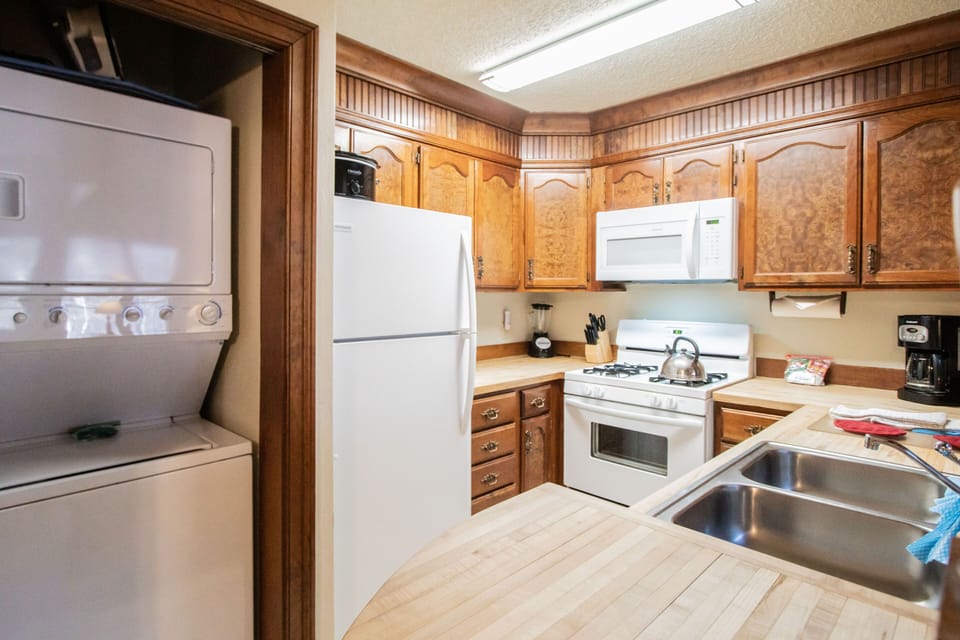 The full kitchen boasts traditional wooden cabinetry and modern appliances, making it easy to prepare delicious meals at home.