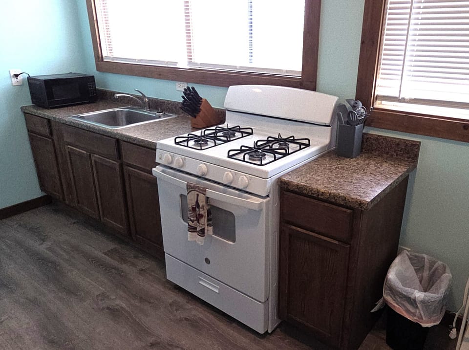 The kitchen has a gas stove, refrigerator, microwave, and coffee maker