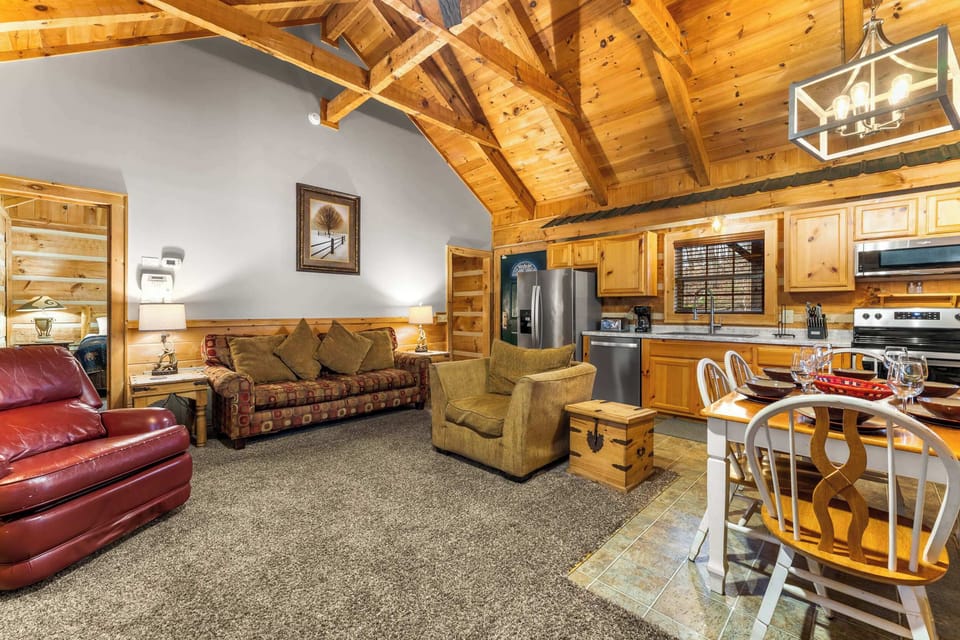 Experience an open-concept living area with vaulted ceilings, a cozy fireplace, and a full kitchen.