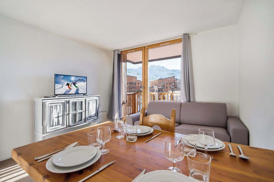 Warm wooden dining table ideal for family meals — with easy access to the fully equipped kitchenette.