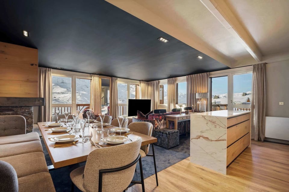 A fully equipped open kitchen with marble island and large dining table — ideal for gathering after a day on the slopes.