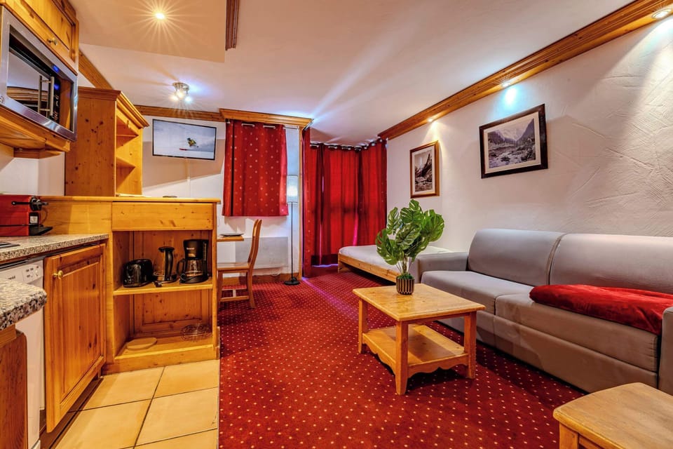 Bright living room with mountain views, sofa and daybed — Rue du Soleil ski-in/ski-out apartment for easy slope access.