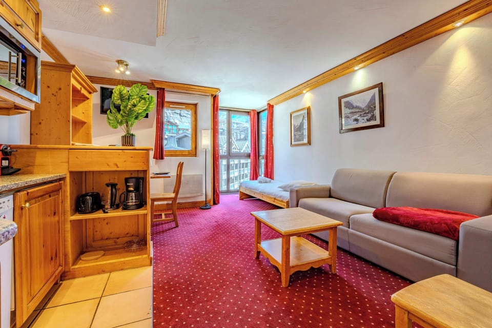 Bright living room with mountain views, sofa and daybed — Rue du Soleil ski-in/ski-out apartment for easy slope access.