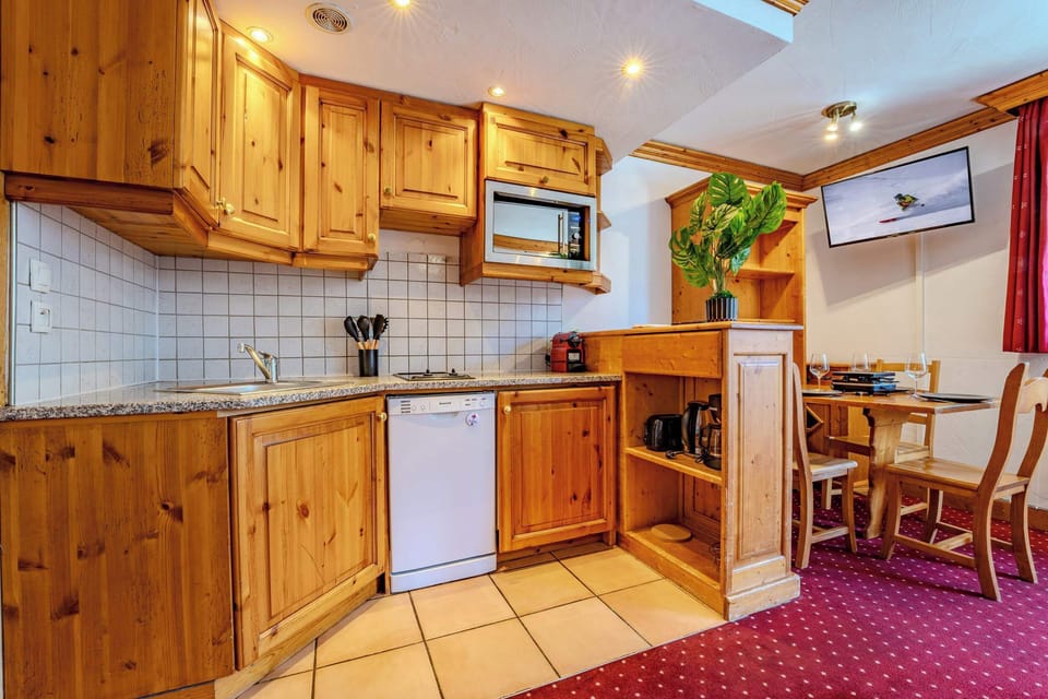 Fully equipped alpine kitchen: hob, microwave, dishwasher, coffee makers — Val Thorens apartment near shops and restaurants.