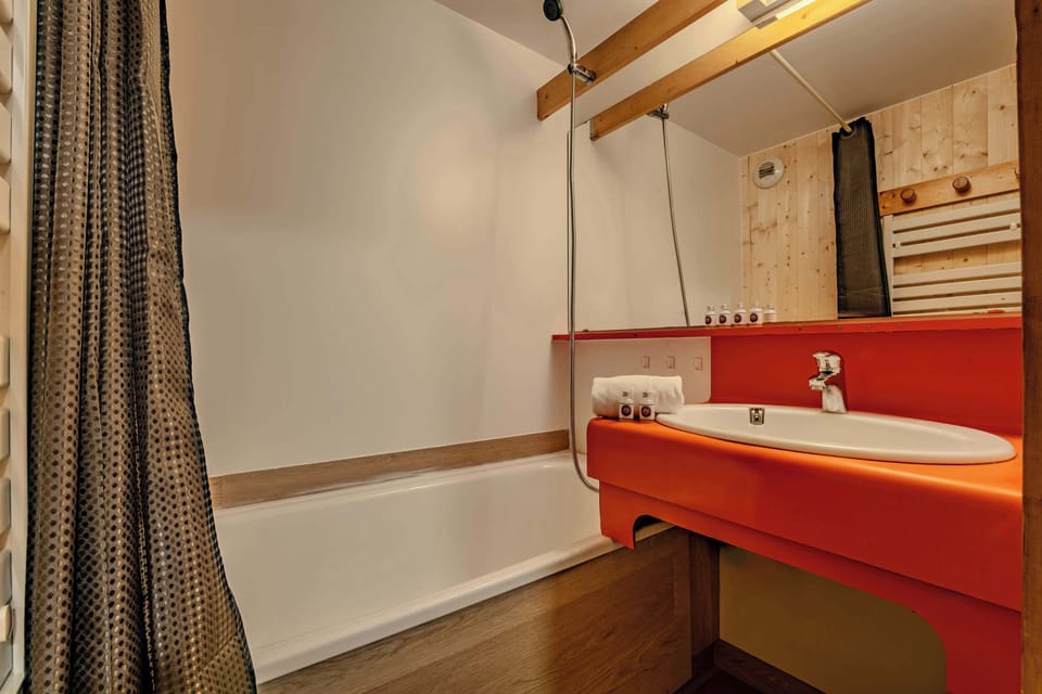 Bright bathroom with shower-over-tub and heated rail — Val Thorens studio near lifts, perfect for relaxing after skiing the 3 Valleys.