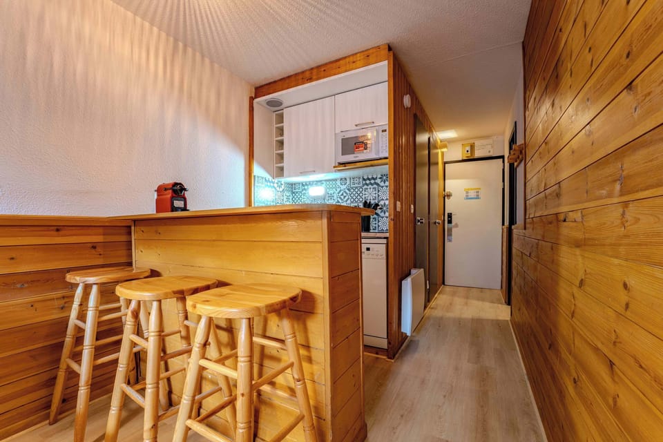 Warm wood breakfast bar with stools and coffee machine — Rue du Soleil Val Thorens studio near lifts and ski schools.