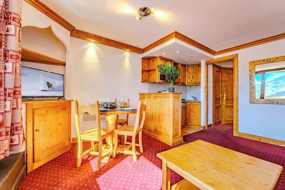 Dining table beside kitchen — convivial space for fondue & raclette nights after skiing the 3 Vallées.