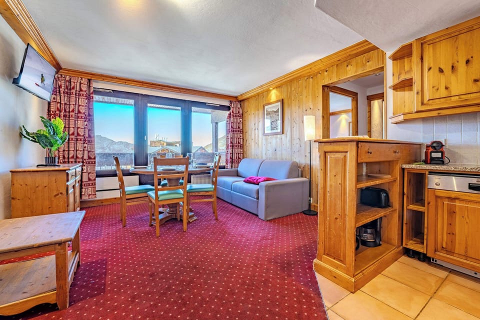 Bright living room with mountain views and dining space—steps from the pistes and lifts; cozy après-ski moments in Val Thorens, Les Belleville.
