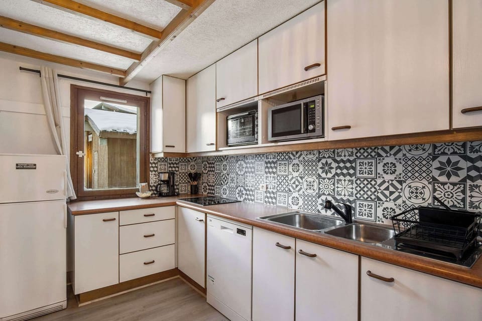 Modern kitchen with dishwasher, coffee maker, oven, and microwave—everything you need for a self-catered ski holiday.