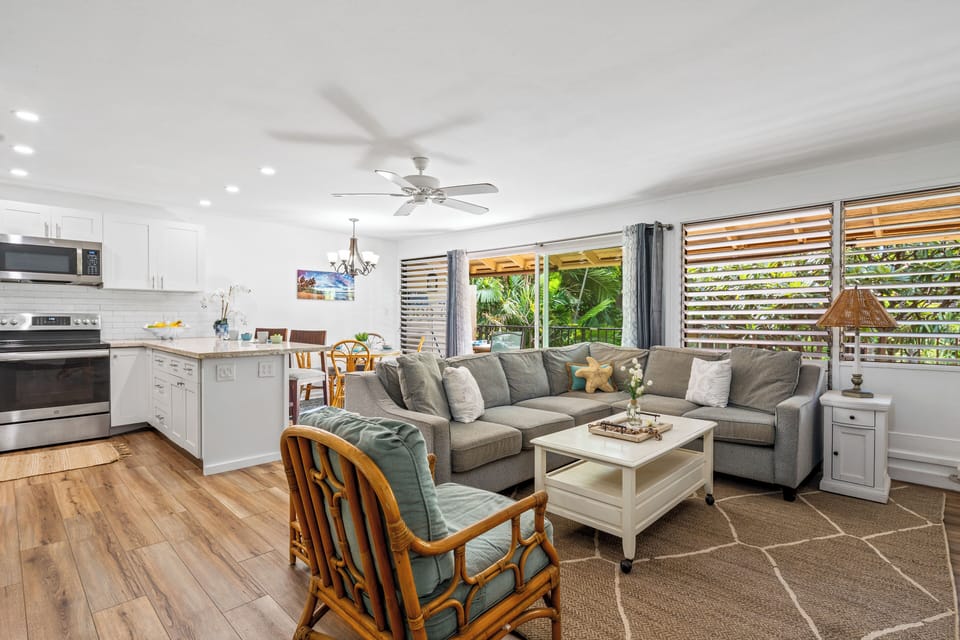 Spacious open-concept layout featuring living area, full kitchen with island, and warm wood flooring