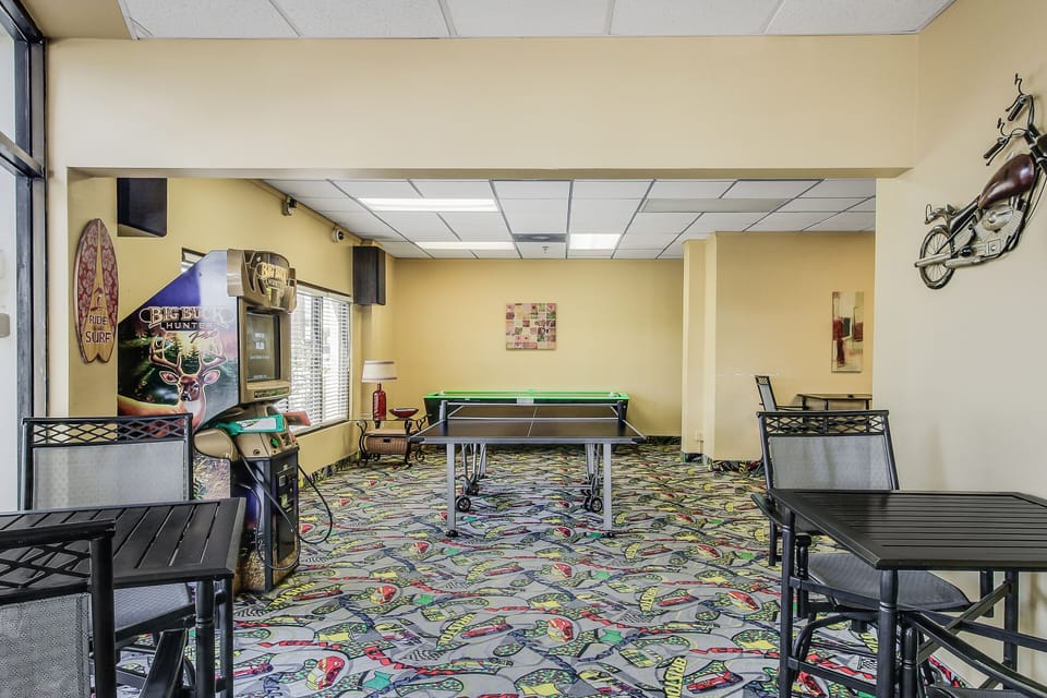 Enjoy extra entertainment during your beach stay in this recreation room with arcade games, table tennis, and casual seating—perfect for relaxing and having fun beyond the sand and surf.