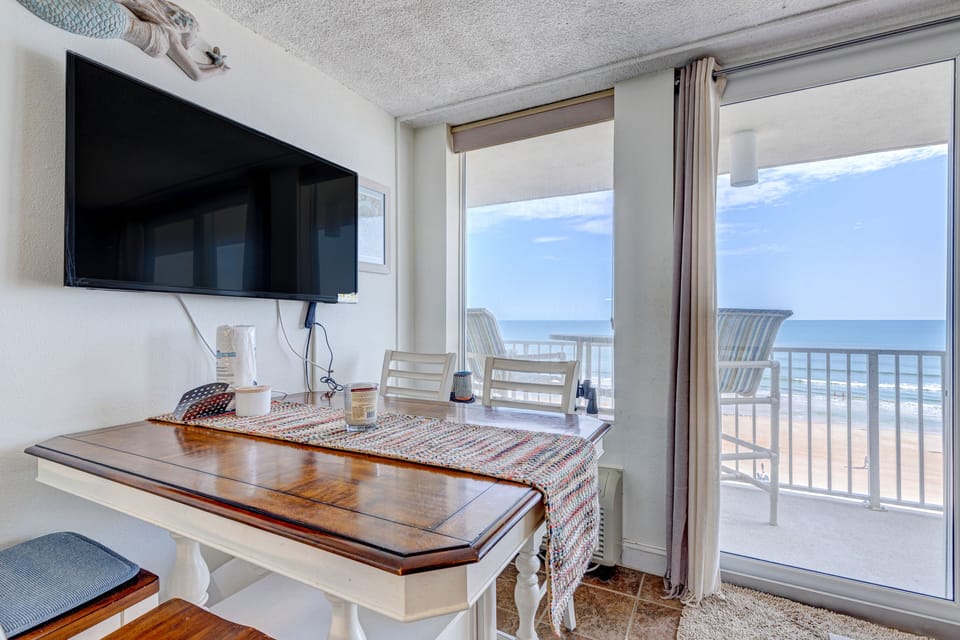 Enjoy meals with a view in this oceanfront beach stay dining area featuring natural light, balcony access, and sweeping shoreline views—perfect for morning coffee or sunset dinners by the sea.