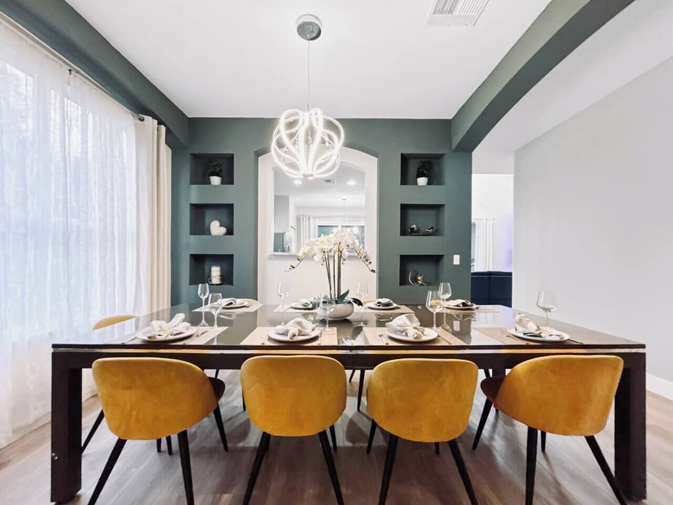 A modern, beautifully designed dining room with a sleek table and comfortable seating for up to 12. With the dramatic built-ins and elegant lighting, it is ideal for memorable family meals and holiday gatherings during your Orlando stay.