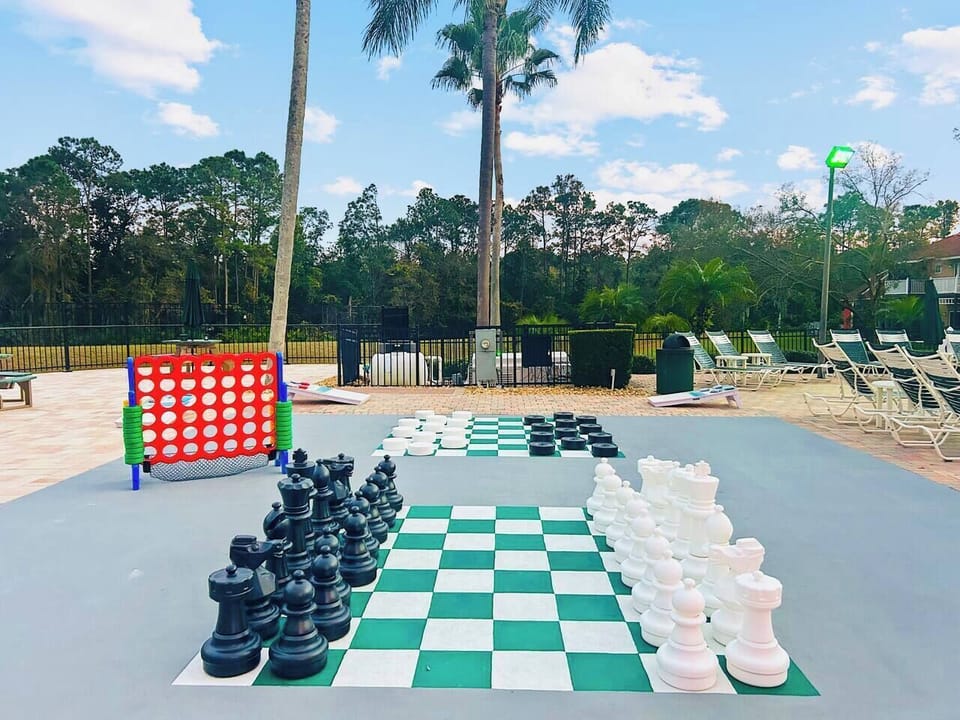 Outdoor games area featuring giant chess, oversized Connect 4, and cornhole—perfect for family fun. Located steps from the clubhouse and pool, this space offers playful, resort-style entertainment for guests of all ages.