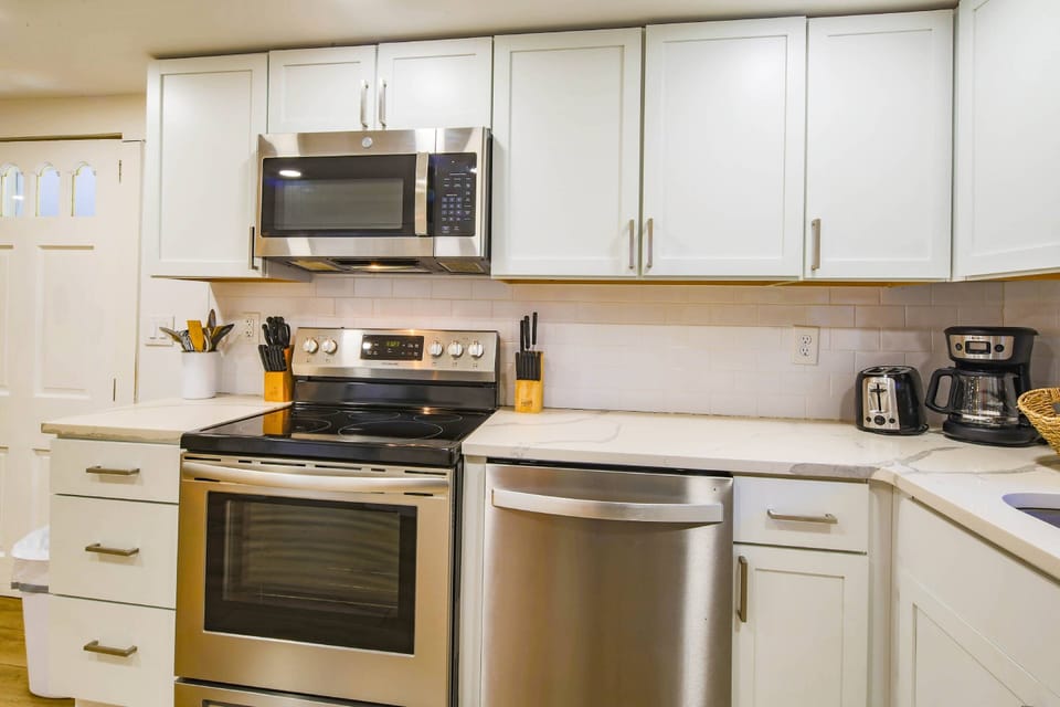The kitchen features an electric range, microwave, drip coffee maker and toaster.