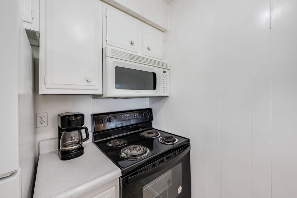 Your fully equipped kitchen features a microwave, electric stove, and coffee maker ready for your morning brew and home-cooked meals.