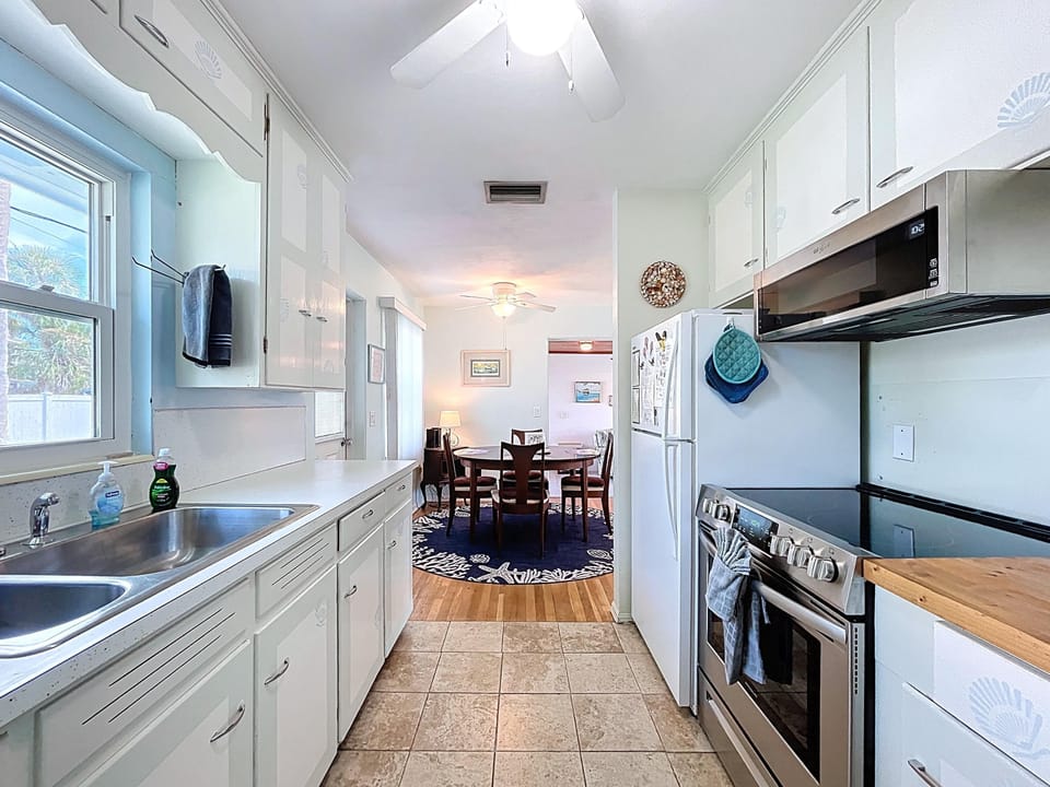 Fully equipped kitchen with stainless electric range, microwave and full size refrigerator