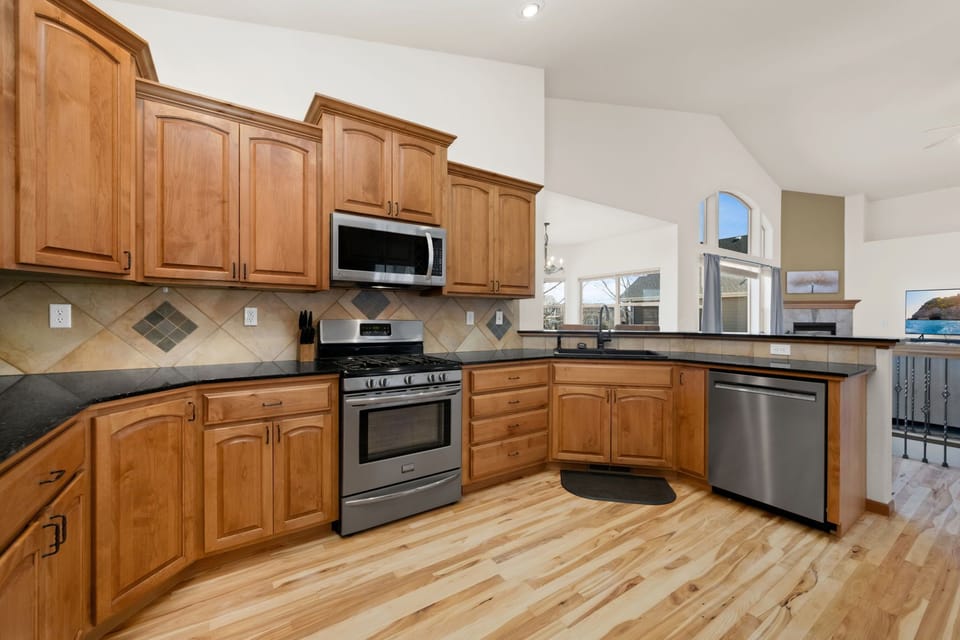 Your spacious kitchen features warm wood cabinets, granite counters, and stainless steel appliances - perfect for preparing memorable meals during your stay.