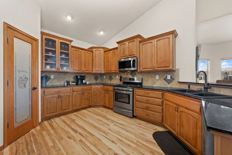 Your spacious kitchen features warm wood cabinets, granite counters, and modern appliances - perfect for preparing memorable meals during your stay.