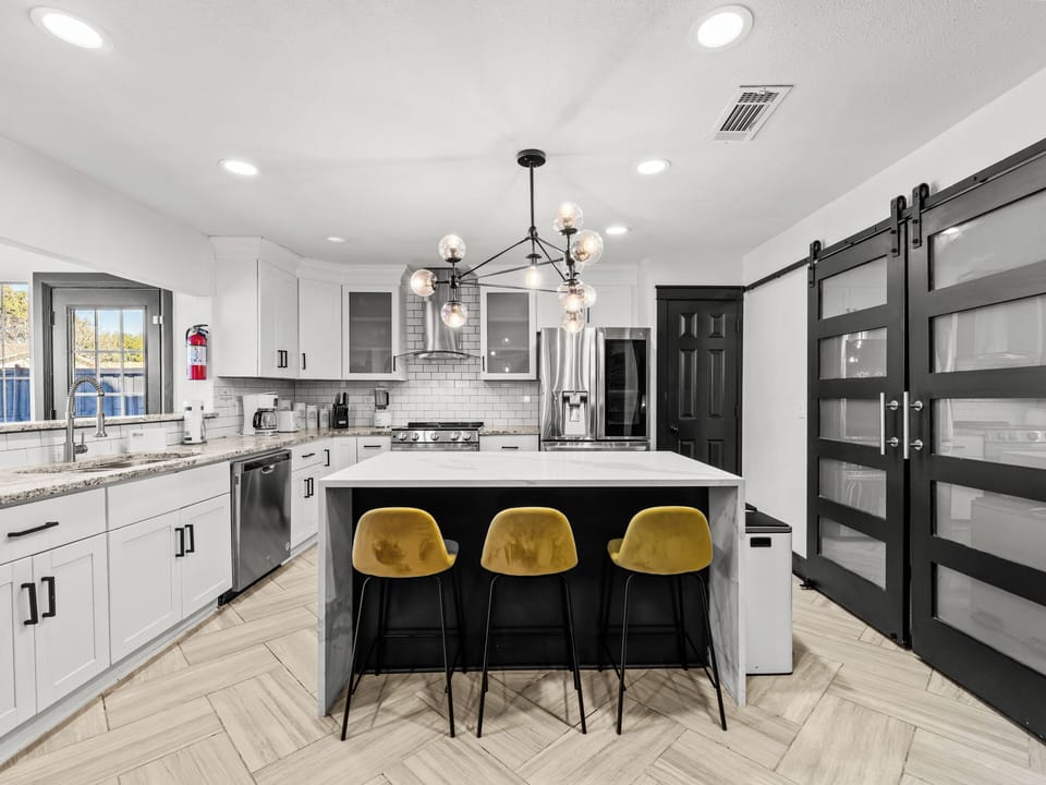 Your modern kitchen awaits with marble island seating, premium appliances, and stylish gold accents for memorable meal prep moments.