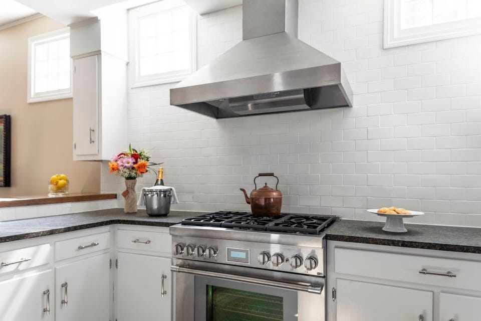 This modern chef's kitchen showcases sleek stainless steel appliances and a bright, airy ambiance, ideal for culinary creations.
