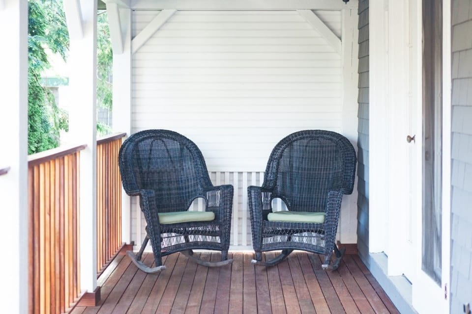 Relax in the charming rocking chairs on the peaceful porch of Ivy Cottage, offering a perfect spot to unwind and enjoy the fresh coastal breeze.