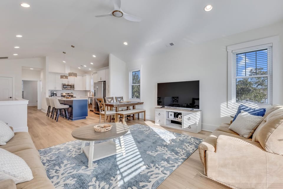 Relax in your bright, open living space where natural light creates beautiful patterns across comfortable seating and modern amenities.