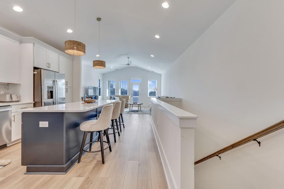 Gather around your spacious kitchen island with stylish pendant lighting, where morning coffee flows into evening conversations in this bright, open-concept space.