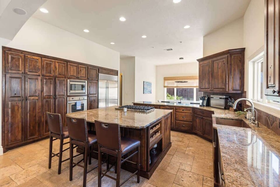 The heart of the home: a gourmet kitchen with warm wood cabinets, granite counters, and stainless steel finishes. Ideal for family dinners, entertaining, or simply enjoying a glass of wine while you cook.