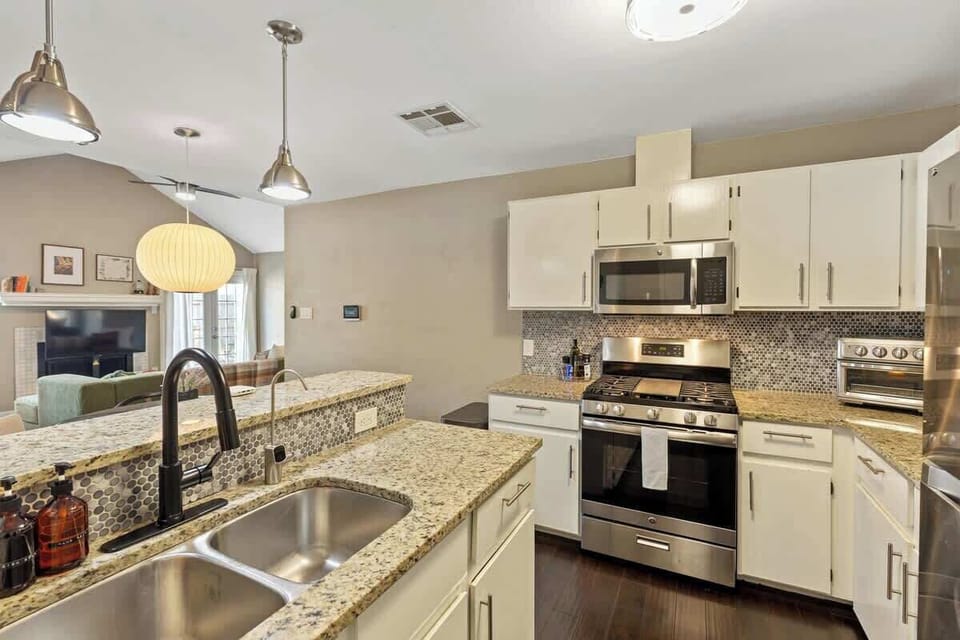 Open-concept kitchen connecting to the dining and living room, fully equipped with stainless steel appliances.