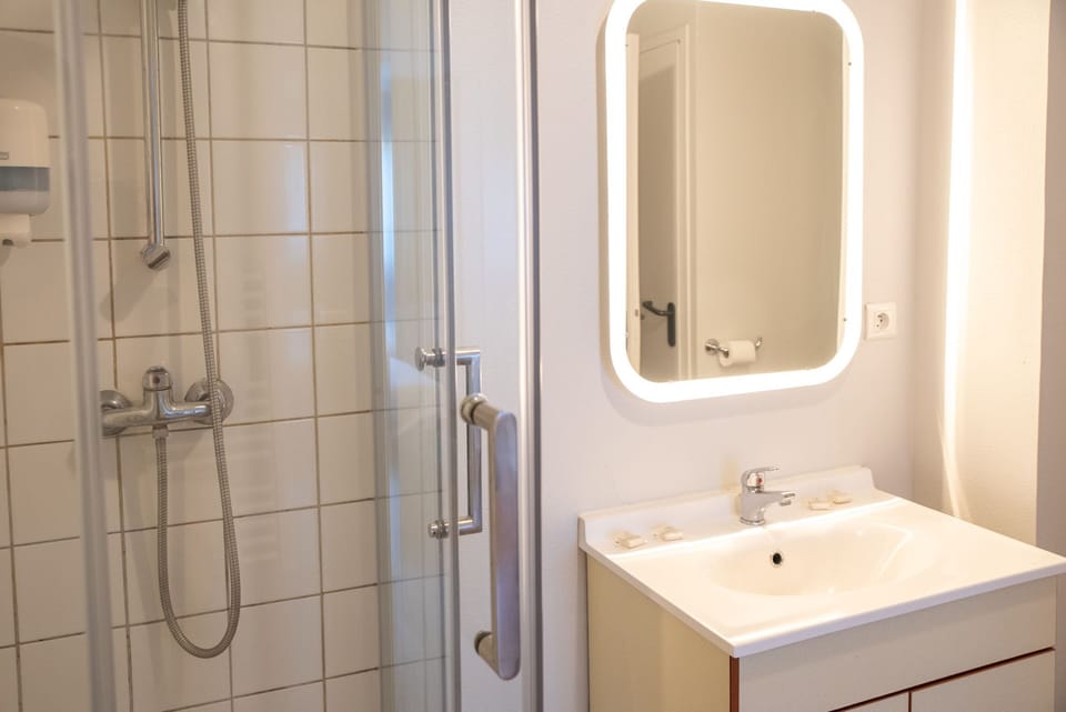 The bathroom features a clean, functional shower and vanity for everyday comfort.