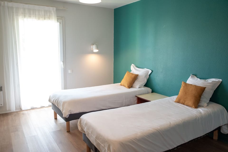 The twin-bed sleeping area is filled with natural light for a pleasant, restful atmosphere.