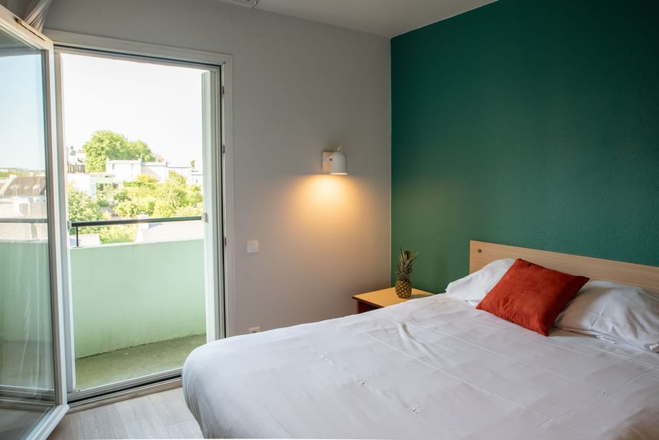 The sleeping area opens toward the balcony, bringing in natural light and fresh air.