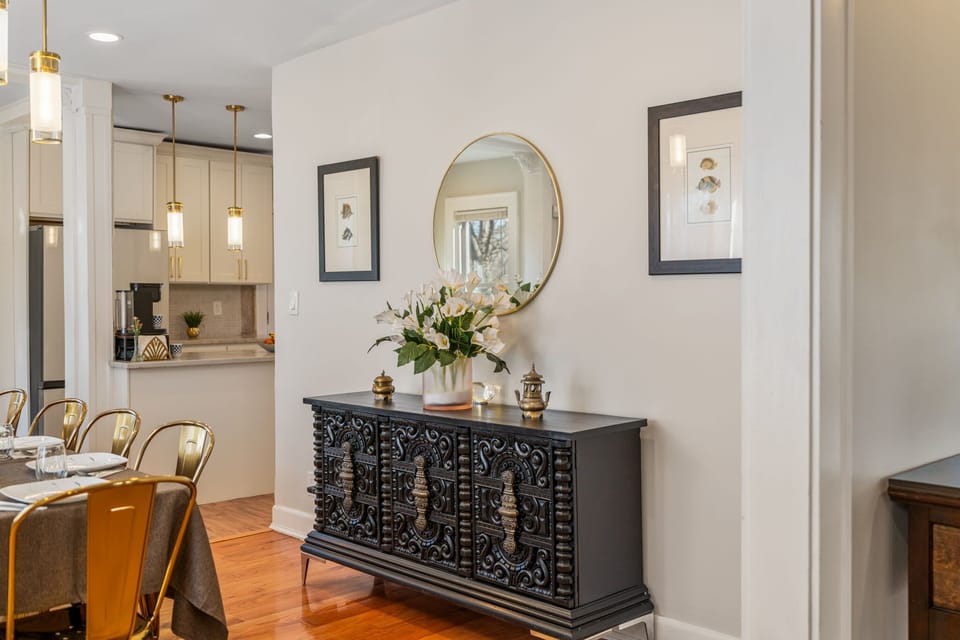 Stylish sideboard with intricate detailing and a round mirror above. Adds both storage and visual interest. Thoughtfully styled for a polished look.