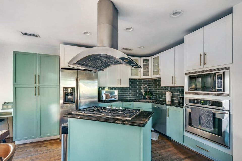 Fully equipped modern kitchen with island, stainless steel appliances, and ample prep space.
