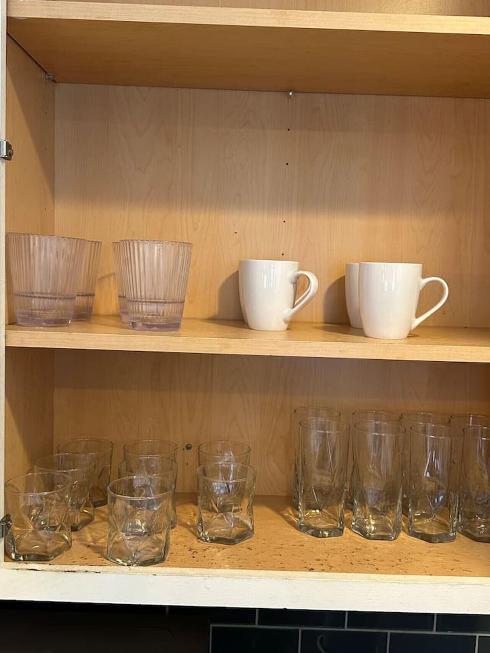 Fully stocked kitchen with glasses, mugs, and dining essentials.
