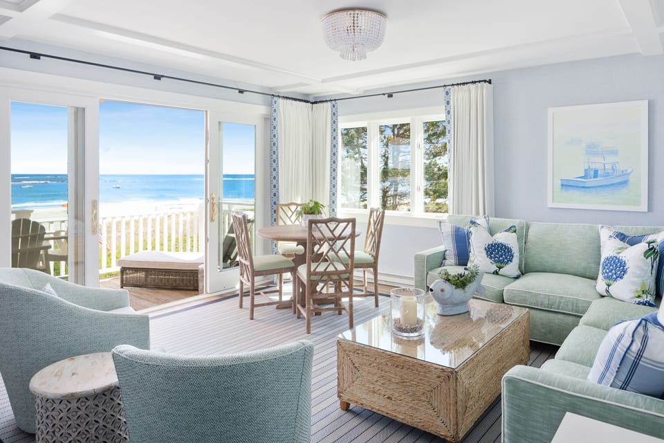 The spacious living area invites you to unwind with its coastal decor and ample natural light, all while being just steps from the beach.
