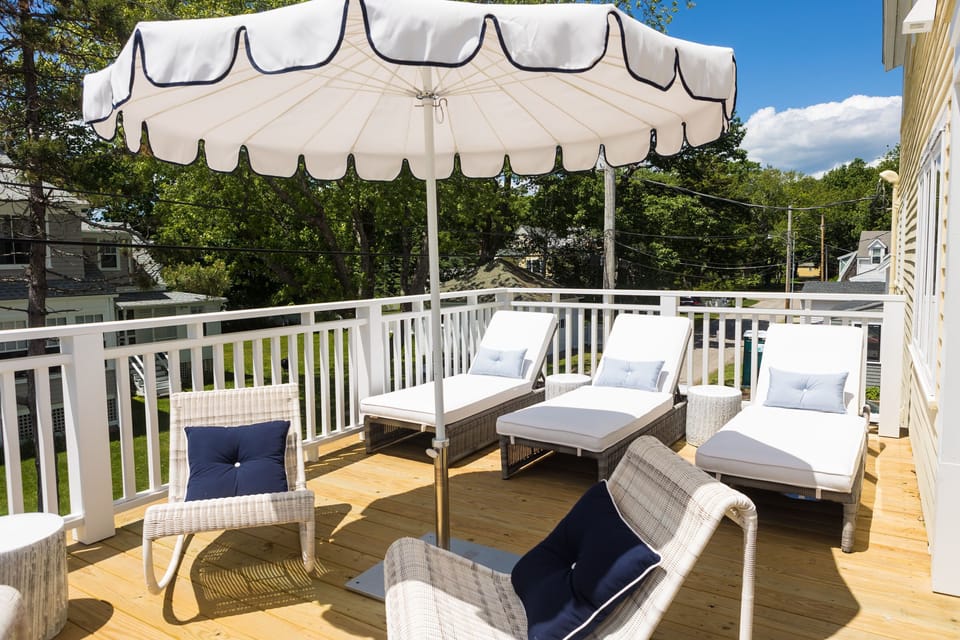 Relax in style on the sunlit terrace, featuring lounge chairs and an umbrella for perfect afternoons soaking in the sun at Belair.