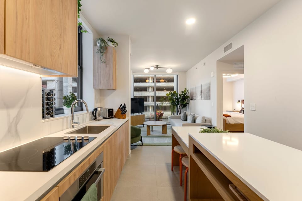 Modern kitchen with island seating and sleek wood cabinetry.