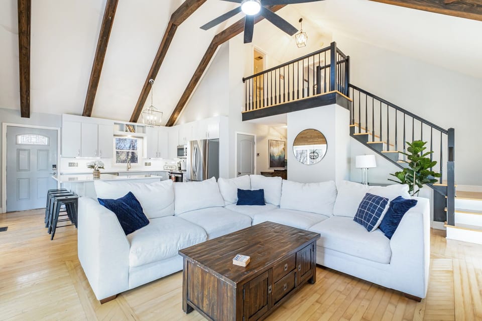 Living area with large, sectional, fireplace, TV and sliders to the deck.