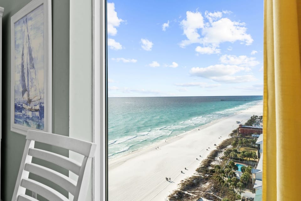 A floor‑to‑ceiling window brings in beautiful natural light and frames stunning beach views while you dine.
