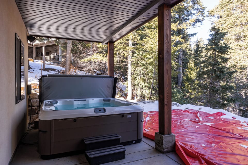 Relaxing private hot tub set among mature trees, offering a peaceful forest backdrop—perfect for unwinding after a day of skiing, hiking, or exploring.