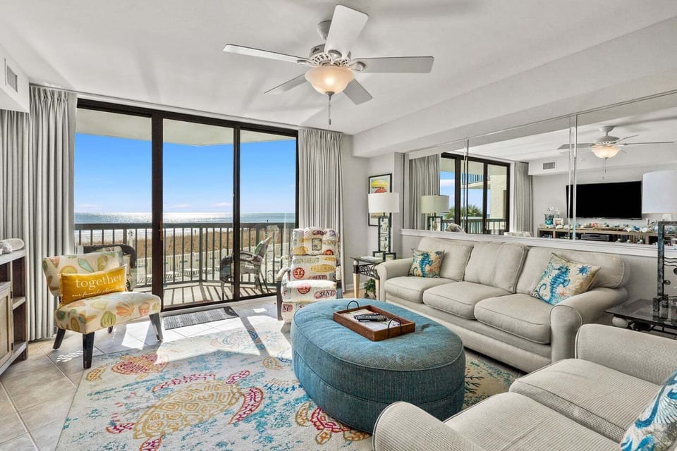Sectional sofa and ottoman facing the ocean-view sliders at Ocean Bay Club 107, Ocean Drive
