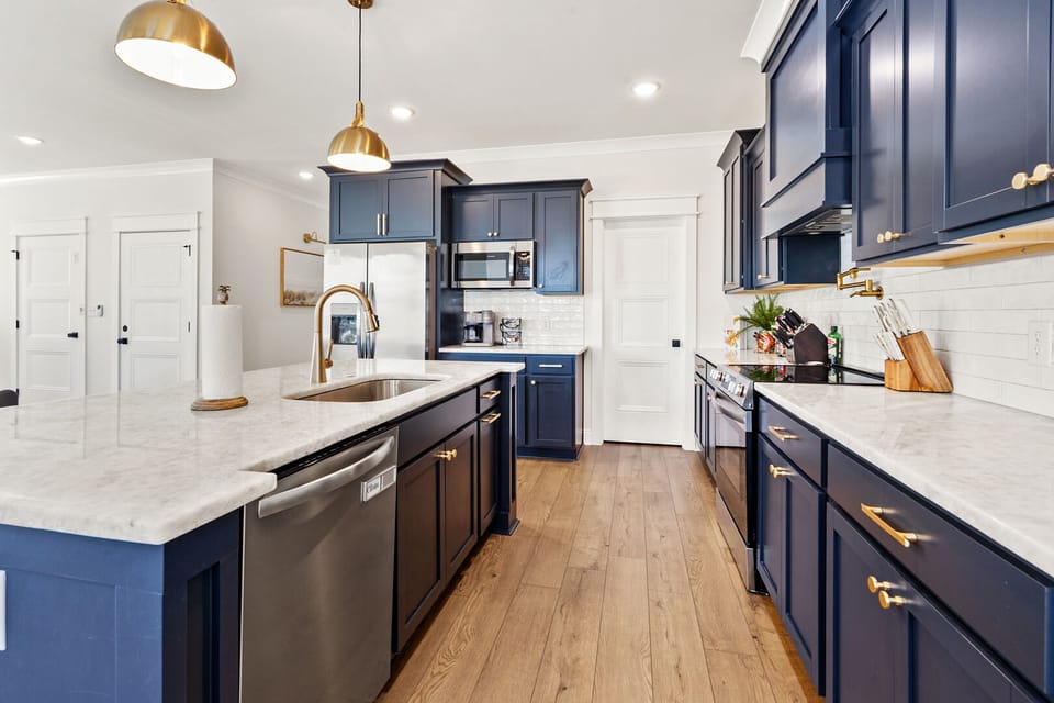 Kitchen with blue cabinets, gold fixtures and light counters at Lost Shaker of Salt in Cherry Grove